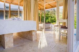 Agia ParaskeviにあるBungalows Panstel in Kerames Rethymnoのベッド、テーブル、椅子が備わる客室です。
