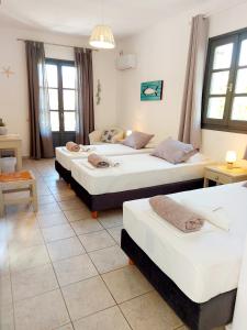 Un grupo de 4 camas en una habitación en Villa Del Mar, en Antíparos