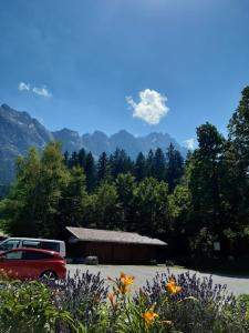 un coche aparcado en un estacionamiento con montañas en el fondo en Ferienwohnung Dana en Murnau am Staffelsee