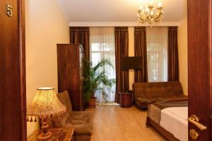 a living room with a bed and a couch at Hotel British House in Tbilisi City