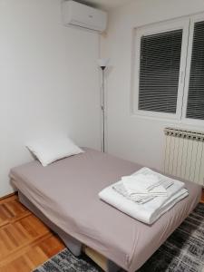 uma cama branca num quarto com uma janela em Apartman Radulović em Kladovo