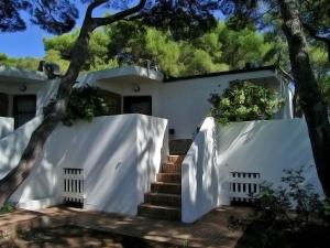 a white house with a white fence and stairs at Hotel Kyrie Isole Tremiti in San Domino