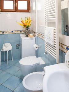 baño con aseo y jarrón de flores en Casa Vacanza La Gardenia en Tramonti