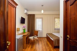 a small room with a bed and a desk and a table at Hotel British House in Tbilisi City