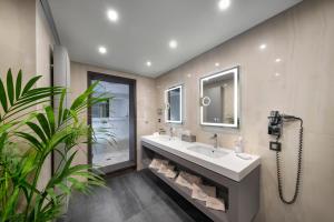 a bathroom with a sink and a mirror at Iakovakis Suites & Spa in Koropi
