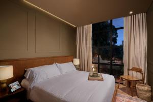 a bedroom with a bed and a large window at Hotel Coco in Bogotá