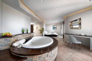 a large bathroom with a large tub in a room at Iakovakis Suites & Spa in Koropi