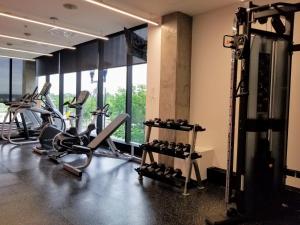 a gym with several tread machines in a room with windows at Alt Hotel Calgary East Village in Calgary