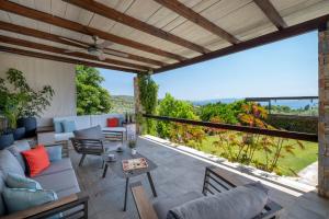 a patio with a couch and chairs and a table at Iakovakis Suites & Spa in Koropi