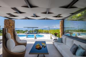 sala de estar con vistas a la piscina en Iakovakis Suites & Spa, en Koropi