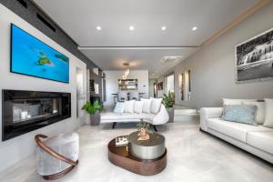 a living room with white furniture and a fireplace at Iakovakis Suites & Spa in Koropi