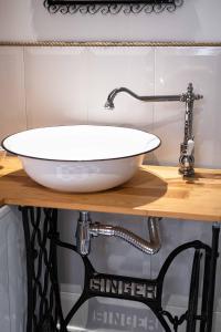 a white sink on a wooden counter in a bathroom at Sarego PREMIUM Apartament in Kraków