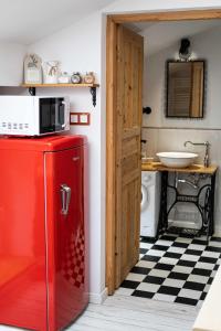a red refrigerator in a kitchen with a microwave at Sarego PREMIUM Apartament in Kraków