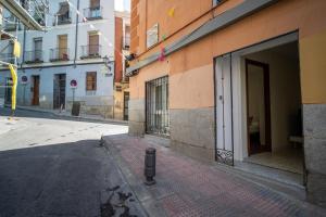 een lege straat naast een gebouw met een deur bij El Jardín del Ángel Tribulete in Madrid
