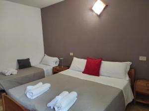 1 dormitorio con 2 camas y toallas. en Albergo Stella D'Italia, en Tenno