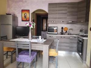 a kitchen with a table with a vase of flowers on it at Holiday Sun in Badesi