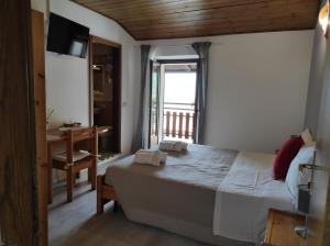 1 dormitorio con cama, escritorio y ventana en Albergo Stella D'Italia, en Tenno