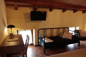 PolcenigoにあるAlbergo Rurale Parco di San Florianoのベッドルーム(ベッド1台、テーブル、テレビ付)