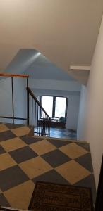 an attic room with a checkered floor and stairs at TOMiSLAV in Zagreb