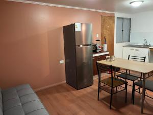 Il comprend une cuisine équipée d'un réfrigérateur en acier inoxydable et d'une table. dans l'établissement Cabañas Caur, à San Pedro de Atacama