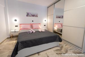 um quarto com uma cama grande e almofadas cor-de-rosa em Central lux house em Kalamata
