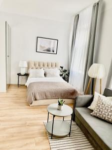 una camera con letto, divano e tavolo di Suites by Riga Old Town a Riga