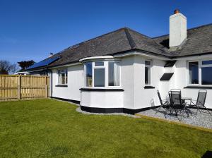 a white house with a table and chairs in a yard at Trevose, sea views in Port Isaac
