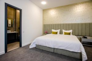 葉瑞文的住宿－Benefice Hotel Yerevan，卧室配有一张带黄色枕头的大型白色床。