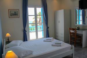 a bedroom with a bed and a desk and a window at Sea View Studios & Apartments in Agia Anna Naxos