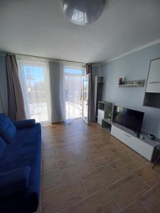 sala de estar con sofá azul y TV en To8 apartman, en Dunapataj