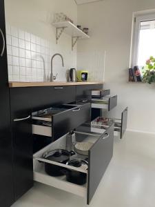 a kitchen with black cabinets and a sink at Petit Appartement in Hapberg