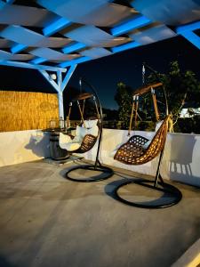 a couple of chairs sitting on a patio at Family Villages Santorini in Vlychada Beach
