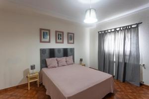 a bedroom with a white bed and a window at Vivenda Esgravina in Sesimbra +31 photos