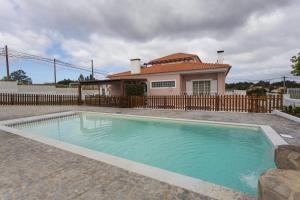 a swimming pool in front of a house at Vivenda Esgravina in Sesimbra
