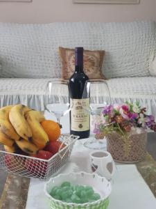 a table with a basket of fruit and a bottle of wine at Zen House in Cetinje