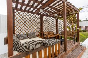 a wooden gazebo with a bed on a deck at Vivenda Esgravina in Sesimbra