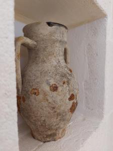 an old vase sitting in a corner of a wall at Il Vicolo Grottaglie in Grottaglie