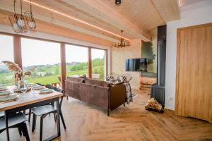 a living room with a large couch and a table at Domki Widokowelove z widokiem na panoramę Tatr - mountain view in Gliczarów