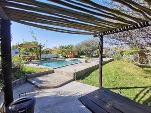 a backyard with a swimming pool and a pergola at Achab Eco cabin in Usakos