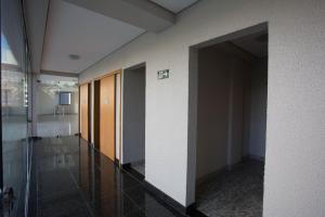 an empty hallway in a building with a door open at Locking's Lourdes 10 in Belo Horizonte