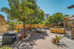 un patio con mesas, sillas y árboles en Domus Vesuvia, en Torre Annunziata