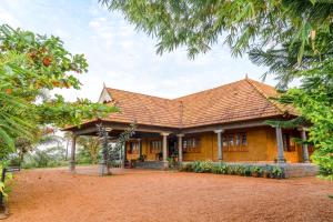 a house with a brown roof at Woodgreens Heritage Resorts in Kannur