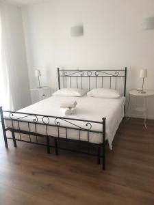 a bed with a black frame and white sheets at Affittacamere Da Ilaria in Sottomarina