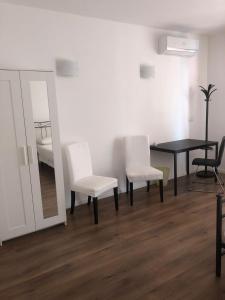 ソットマリーナにあるAffittacamere Da Ilariaのテーブル、椅子2脚、鏡が備わる客室です。