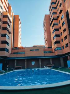 an empty swimming pool in front of two tall buildings at Double Room with bathroom in Alicante