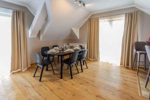 uma sala de jantar com mesa e cadeiras em VacationClub - Rezydencja Karkonoska Apartament 10 em Karpacz