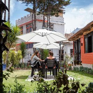 two women sitting in chairs under an umbrella at Jo´s Place in Huaraz