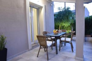 a table with chairs and a bowl of fruit on a patio at Mama’s house in Ágios Rókkos +7 photos
