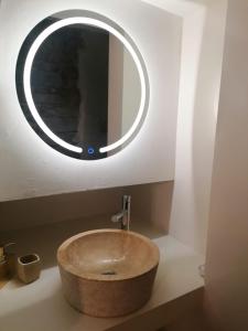 un lavandino da bagno con sopra uno specchio circolare di BED and BIKE - BERGAMO Pignolo 53 a Bergamo