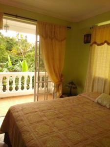 1 dormitorio con 1 cama y balcón con ventana en Posada Natytali en San Andrés